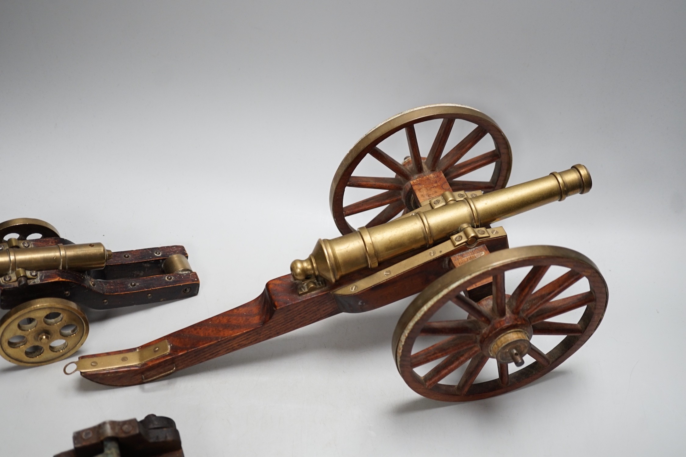 A bronze 'Napoleon bust' desk seal, 8.5cm tall, together with four models of cannons. Largest 39cm wide